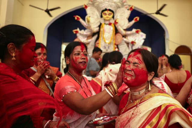 Devotees take part in a ritual 'Sindoor Khela' wherein married women anoint each other with vermilion powder ahead of the immersion of the idol of Hindu goddess “Durga” during the Hindu festival 'Durga Puja' in Varanasi on October 13, 2024. (Photo by Niharika Kulkarni/AFP Photo)