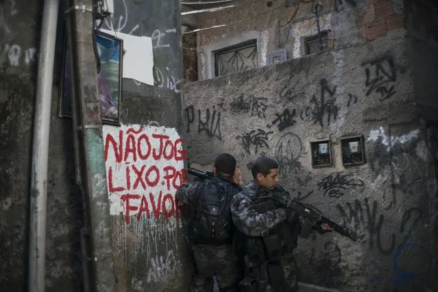 Officers take positions during a police operation against drug traffickers in the Jacarezinho slum of Rio de Janeiro, Brazil, Wednesday, June 29, 2016. Recent violence is adding to worries about safety in Rio during the Olympics. Officials have warned that budget shortfalls may compromise security during the games.  (Photo by Felipe Dana/AP Photo)