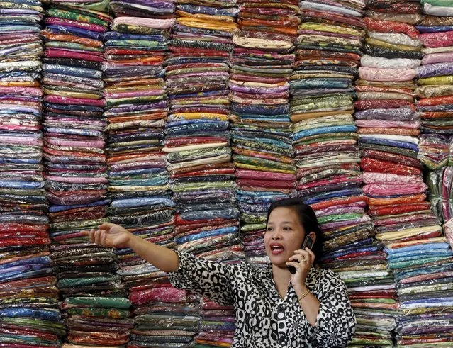 Fadhilah Arshad, a businesswoman, talks to a supplier as she sells cloth at her bazaar in Kuala Lumpur in this December 1, 2009 file photo. Malaysia is expected to release July CPI data this week. (Photo by Bazuki Muhammad/Reuters)