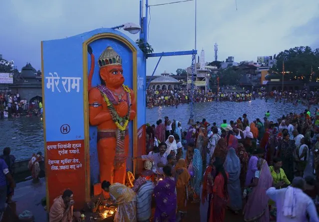 Devotees pray in front of an idol of the Hindu monkey god Hanuman, on the banks of Godavari river during Kumbh Mela or the Pitcher Festival in Nashik, India, August 26, 2015. (Photo by Danish Siddiqui/Reuters)