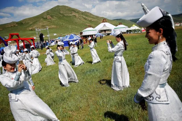 Performers wearing traditional clothes take pictures of themselves as they wait delegations to arrive for traditional nomadic Naadam festival performance during the Asia-Europe Meeting (ASEM) summit just outside Ulaanbaatar, Mongolia, July 15, 2016. (Photo by Damir Sagolj/Reuters)