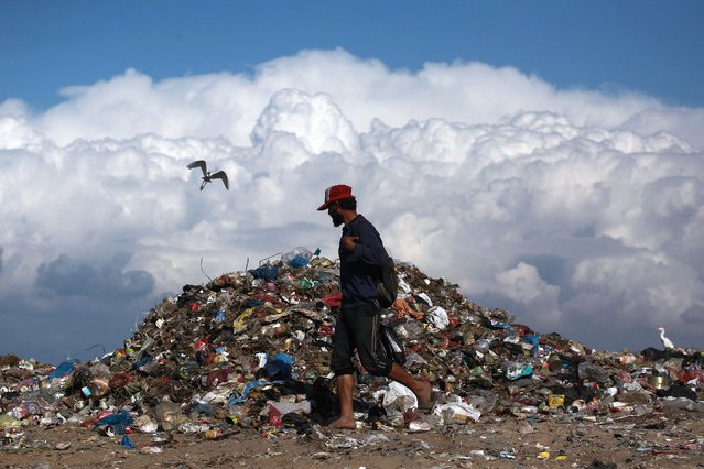 A man walks past a pile of garbage as he searches for things to rescue amid a humanitarian crisis the Gaza Strip, in Deir el Balah in central Gaza, on November 19, 2024, as the war in the Palestinian territory between Israel and Hamas continues. (Photo by Bashar Taleb/AFP Photo)