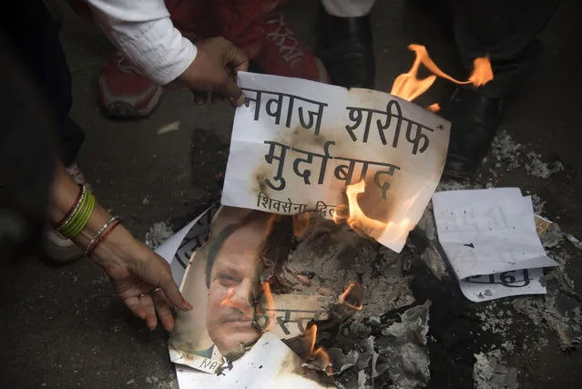 Supporters of India's hardline “Shiv Sena” or Army of Shiva party burn an effigy of Pakistani Prime Minister Nawaz Sharif as they protest in New Delhi, India, Tuesday, July 19, 2016. Sharif had called for observing a “black day” on Wednesday to protest India's handling of dissent in Kashmir. Placard in Hindi reads, “Down with Nawaz Sharif”. (Photo by Thomas Cytrynowicz/AP Photo)