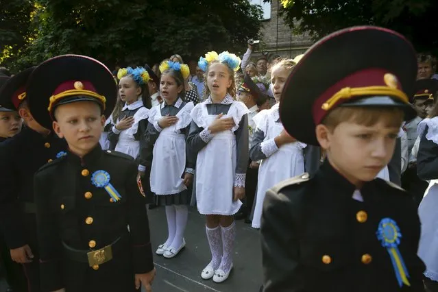 First graders of a cadet's lyceum sing the national anthem during a ceremony to mark the start of the new school year in Kiev, Ukraine, September 1, 2015. (Photo by Valentyn Ogirenko/Reuters)