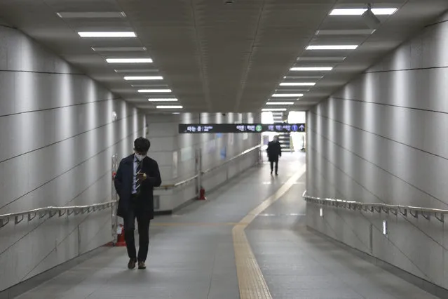 A man wearing a face mask to help protect against the spread of the new coronavirus walks on the underpass in Seoul, South Korea, Thursday, April 2, 2020. For most people, the new coronavirus causes only mild or moderate symptoms, such as fever and cough. (Photo by Ahn Young-joon/AP Photo)