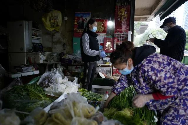People wearing face masks buy vegetables at a street market in Wuhan, Hubei province, the epicentre of China's novel coronavirus disease (COVID-19) outbreak, April 6, 2020. (Photo by Aly Song/Reuters)