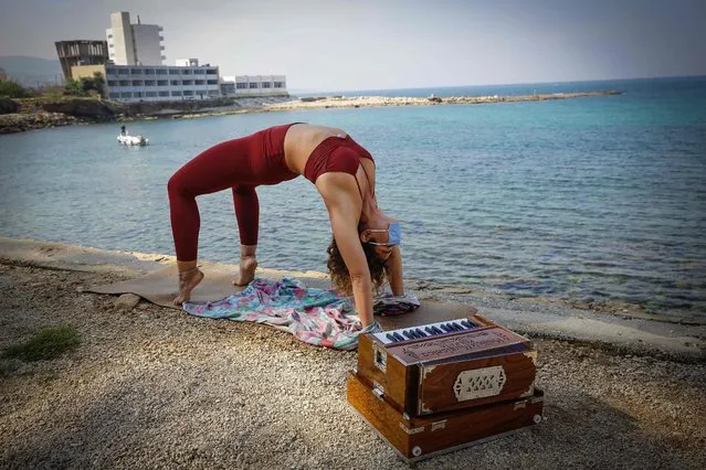 Lebanese yoga instructor Jihane Nasrallah practises morning yoga at the seafront while wearing a mask during COVID-19 coronavirus pandemic in the northern coastal city of Batroun, Lebanon on April 15, 2020. (Photo by Ibrahim Chalhoub/AFP Photo)