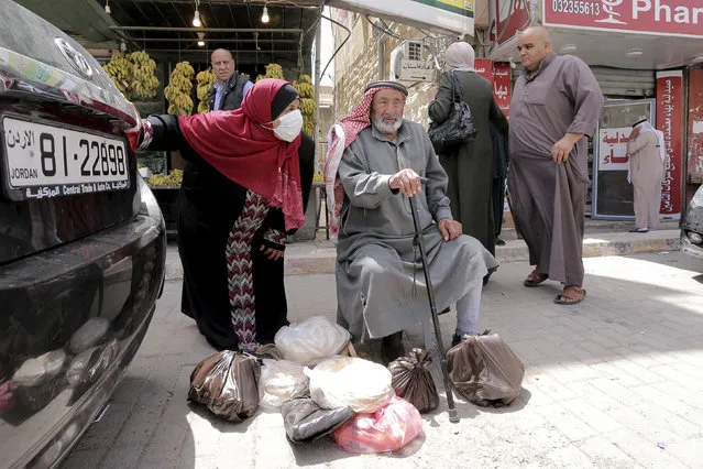 People shop at the main market in Karak, Jordan, after a curfew was lifted for some southern cities, amid concerns about the coronavirus Wednesday, April 22, 2020. Jordan on Wednesday eased movement restrictions in three large and sparsely populated southern districts where no coronavirus cases have been reported. Life began returning to normal in the districts of Karak, Maan and Tefileh. (Photo by Raad Adayleh/AP Photo)