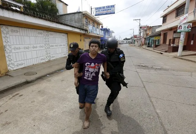 Police officers detain a man during a protest against the re-election of the city's mayor Rubelio Recinos of the Patriot Party in Barberena, northwest of Guatemala City, September 8, 2015. (Photo by Jorge Dan Lopez/Reuters)