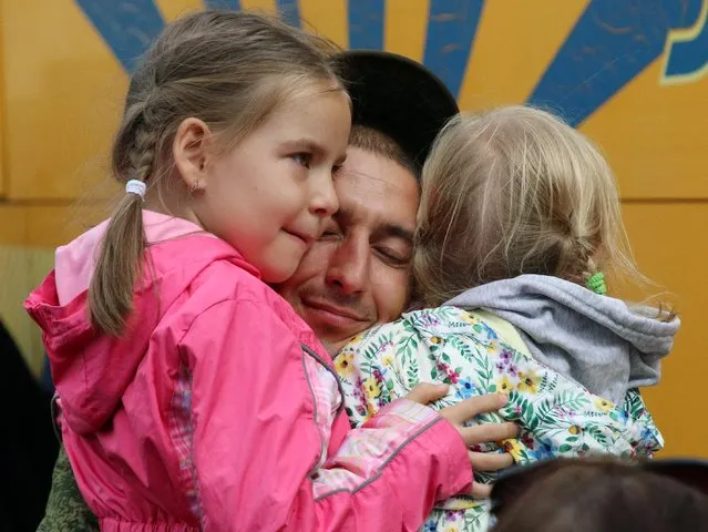 A reservist drafted during the partial mobilisation hugs children before his departure for a military base, in Sevastopol, Crimea on September 27, 2022. (Photo by Alexey Pavlishak/Reuters)