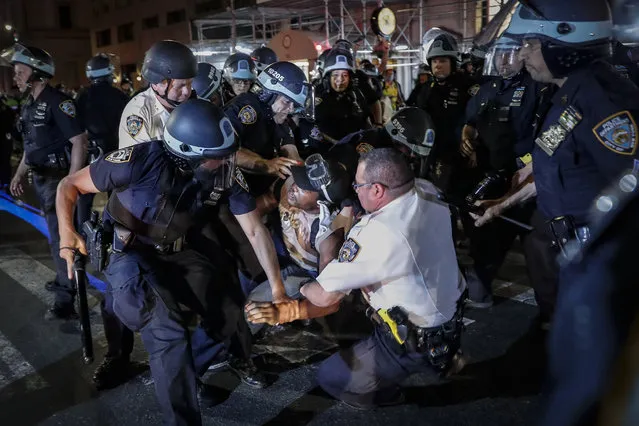 A protester is arrested on Fifth Avenue by NYPD officers during a march, Thursday, June 4, 2020, in the Manhattan borough of New York. Protests continued following the death of George Floyd, who died after being restrained by Minneapolis police officers on May 25. (Photo by John Minchillo/AP Photo)