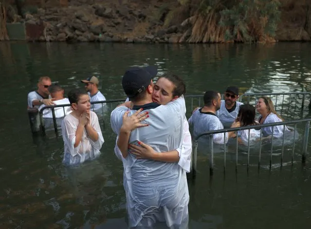 Evangelical Christian pilgrims from Brazil attend a mass baptism ceremony in the waters of the Jordan River at Yardenit in northern Israel on October 10, 2022. According to the gospel Jesus Christ was baptized in the water of the Jordan River by John the Baptist. Evangelical pilgrims arrived in Israel during the Jewish holiday of Sukkoth or the Feast of Tabernacles to show their support of the Jewish state. (Photo by Menahem Kahana/AFP Photo)