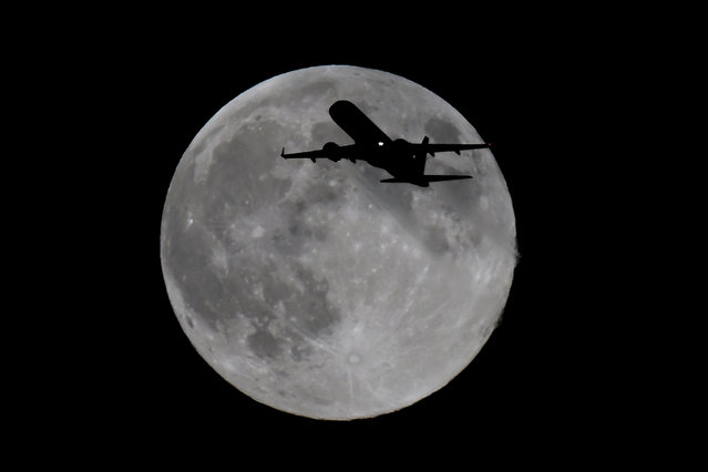 A British Airways Cityflyer from Glasgow heading for London City airport flies past the last Supermoon of 2024 rises in the evening of 15th November 2024. The full Beaver Moon ends a run of four consecutive supermoons throughout 2024. (Photo by Martin Dalton/Rex Features/Shutterstock)