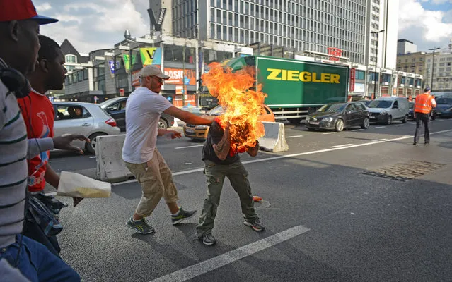 A man sets himself alight during a demonstration of refugees in Brussels, on October 3, 2014. (Photo by Thibault Kruyts/AFP Photo)