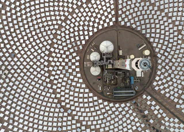 In this aerial view, the tower of the Cerro Dominador concentrated solar and photovoltaic power plant stands atop the Atacama Desert, one of the driest places with the highest solar radiation on earth on August 28, 2022 in Maria Elena, Chile. The concentrated solar power plant (110MW) uses a series of 10,600 mirrors (heliostats), that track the sun, reflecting solar radiation to a receiver on the upper part of a 250 meter tower, the second tallest structure in Chile. The plant, managed by EIG Global Energy Partners, became fully operational in 2021and is the only such concentrated solar plant in Latin America. The complex also contains a solar photovoltaic power plant (100 MW) for a combined output of 210MW. The project is part of Chile's national renewable energy program with the goal of providing 20 percent of the nation's energy needs from renewable sources by 2025. (Photo by John Moore/Getty Images)