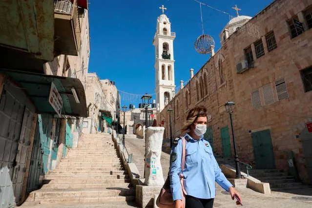 A female Palestinian police officer walks past closed shops in the old quarter of Bethlehem on June 29, 2020, as a decision to close the city for 48 hours as of 6.00am (0300 GMT) takes effect to contain the spread of coronavirus, after a sharp rise in infections in the occupied West Bank. (Photo by Hazem Bader/AFP Photo)