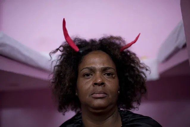An inmate wears red horns as part of her costume representing evil and temptation, during the 8th annual Christmas event at the Nelson Hungria Prison, in Rio de Janeiro, Brazil, Tuesday, December 12, 2017. Inmates who are serving time for offenses from burglary to homicide, spent weeks decking out the cell blocks with the holiday decorations they created. The inmates used materials they had access to behind bars such as plastic bottles, paper, ground-up Styrofoam and aluminum trays. (Photo by Silvia Izquierdo/AP Photo)