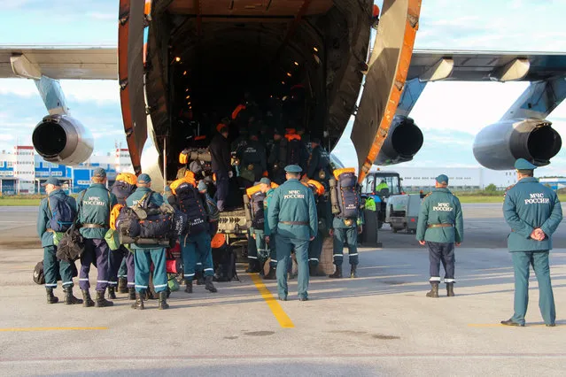 Employees of the Siberian rescue center of the Russian Emergency Situations Ministry are seen by a plane in Novosibirsk Region, Russia on June 4, 2020. The rescuers are sent to Norilsk to clean up a fuel spill. On May 29, a diesel fuel reservoir at Norilsk's Combined Heat and Power Plant No 3 collapsed and nearly 21 thousand cubic meters of fuel spilled into a river. (Photo by Russian Emergency Situations Ministry/TASS)