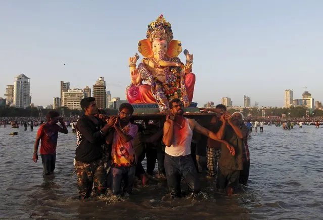 Devotees carry an idol of Hindu elephant god Ganesh, the deity of prosperity, for immersion into the Arabian Sea on the last day of the Ganesh Chaturthi festival in Mumbai, India, September 27, 2015. (Photo by Danish Siddiqui/Reuters)