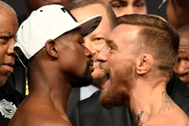 Boxer Floyd Mayweather Jr. (L) and UFC lightweight champion Conor McGregor face off during their official weigh-in at T-Mobile Arena on August 25, 2017 in Las Vegas, Nevada. The two will meet in a super welterweight boxing match at T-Mobile Arena on August 26. (Photo by Ethan Miller/Getty Images)