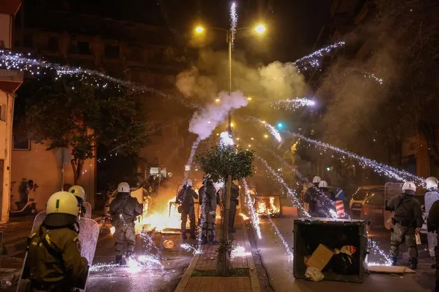 A firework explodes over riot police officers during clashes with demonstrators, following an anniversary rally marking the 2008 police shooting of 15-year-old student Alexandros Grigoropoulos, in Thessaloniki, Greece on December 6, 2022. (Photo by Alexandros Avramidis/Reuters)