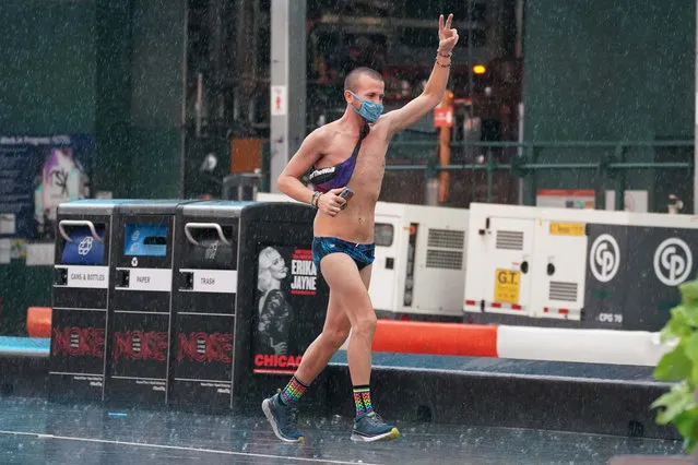 A man runs through wind and rain in Times Square, NYC on August 4, 2020. (Photo by Robert Miller/The New York Post)