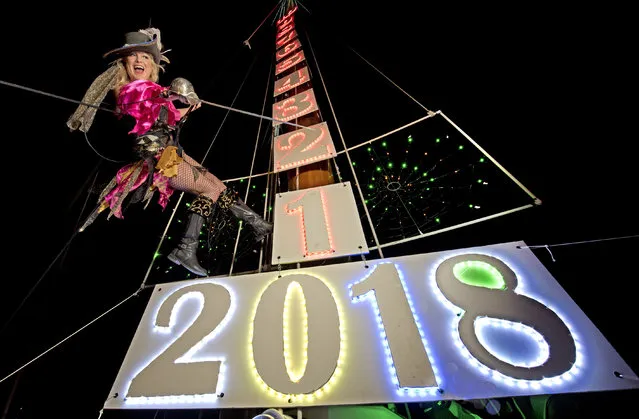 In this Saturday, December 30, 2017, photo, provided by the Florida Keys News Bureau, Evalena Worthington practices her New Year's Eve descent from the top of a tall sailing vessel's mast, dockside at the Schooner Wharf Bar in Key West, Fla. The lowering of the pirate wench is one of several Key West drops planned to mark the arrival of 2018 late Sunday, Dec. 31. (Photo by Rob O'Neal/Florida Keys News Bureau via AP Photo)