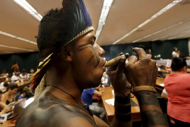An indigenous leader smokes as he occupies the Chamber of Deputies during a protest against the violation of their rights in Brasilia, Brazil, October 5, 2015. (Photo by Lunae Parracho/Reuters)