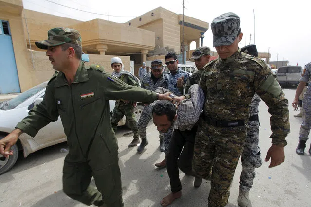 Iraqi security forces arrest a member of the Islamic State in Tikrit, Iraq on April 1, 2015. (Photo by Alaa Al-Marjani/Reuters)