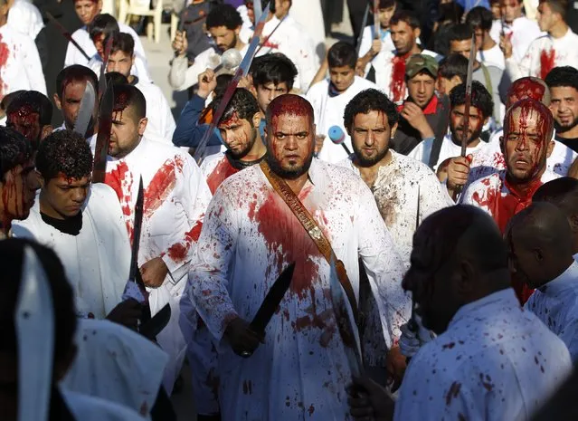 Iraqi Shi'ite Muslims bleed after hitting their foreheads with swords and beating themselves as they commemorate Ashoura in Baghdad, November 4, 2014. More than one million Shi'ite Muslims gathered at shrines and mosques across Iraq on Tuesday for the Ashoura religious ritual with Iraqi security forces on alert for any repeat of the attacks that have inflicted mass casualties during past pilgrimages. (Photo by Thaier Al-Sudani/Reuters)