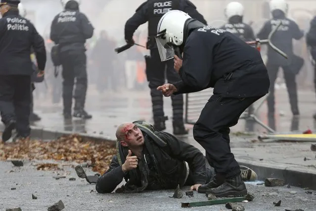 A demonstrator is restrained by riot police during clashes in central Brussels November 6, 2014. (Photo by Francois Lenoir/Reuters)