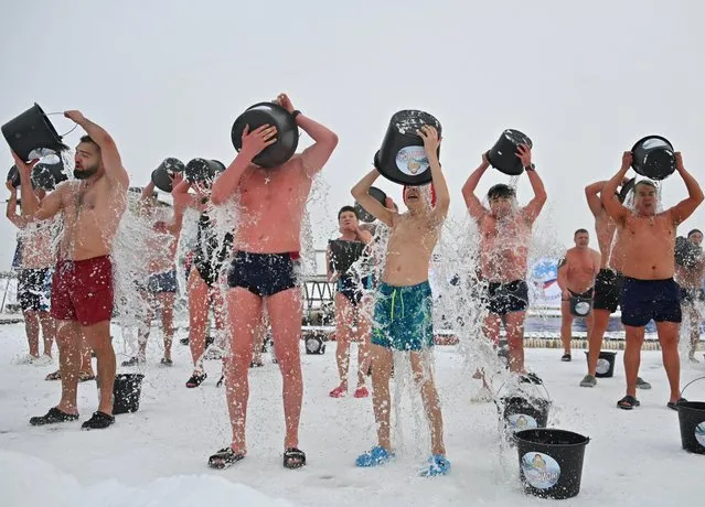Participants douse themselves with icy water during a winter swimming tournament in Tyumen, Russia on December 11, 2022. (Photo by Alexey Malgavko/Reuters)