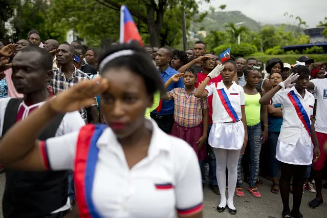 Students salute as the national anthem is played at a ceremony marking Flag Day in Port-au-Prince, Haiti, on May 18, 2017. Haitians celebrated the 214th anniversary of the creation of their national flag Thursday. (Photo by Dieu Nalio Chery/AP Photo)