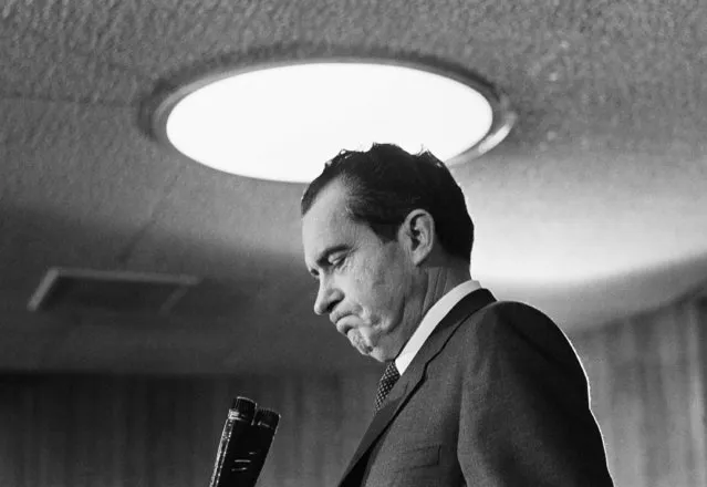 Standing beneath a lighting fixture, President Richard Nixon accepts applause as he begins to address officials and employees at the Department of Housing and Urban Development on February 3, 1969. HUD was one stop on a week's planned tour of government departments. (Photo by AP Photo)