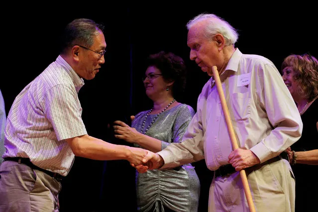 Nobel Laurette Roy Glauber (R) congratulates Atsugi Higashiyama of Japan for winning the 2016 Ig Nobel Prize in Perception for “investigating whether things look different when you bend over and view them between your legs” during the 26th First Annual Ig Nobel Prize ceremony at Harvard University in Cambridge, Massachusetts, U.S. September 22, 2016. (Photo by Brian Snyder/Reuters)