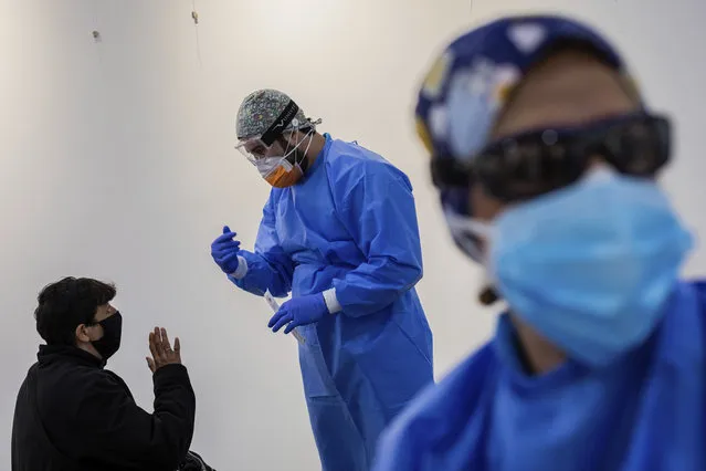 Madrid Emergency Service (SUMMA) health workers conduct rapid antigen tests for COVID-19 in the southern neighbourhood of Vallecas in Madrid, Spain, Friday, October 2, 2020. Madrid and its suburbs are the hardest hit parts of Spain and are preparing to enter a soft lockdown that restricts trips in and out of the capital. (Photo by Bernat Armangue/AP Photo)