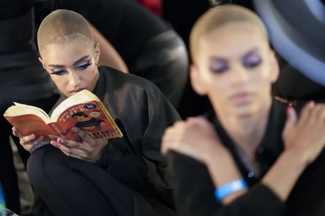 A model reads a book backstage while waiting to get her make-up and hair done before modeling the Sergio Hudson collection during Fashion Week, Saturday, February 11, 2023, in New York. (Photo by Mary Altaffer/AP Photo)