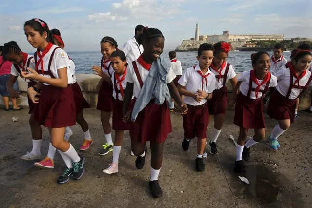 Schoolchildren leave after throwing flowers into the sea in honor of rebel hero Camilo Cienfuegos from Havana's seafront boulevard "Malecon", October 28, 2015. (Photo by Reuters/Stringer)