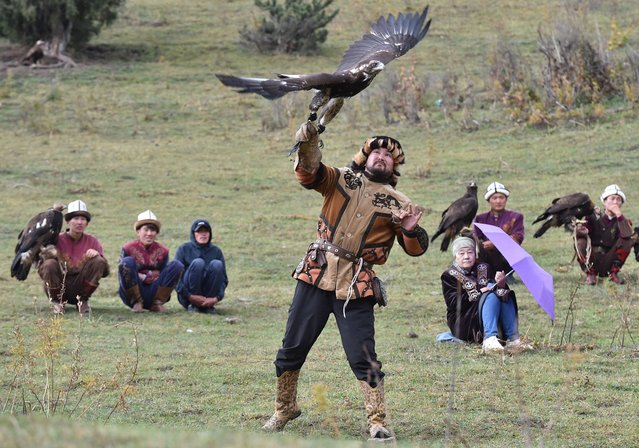 A Kyrgyz “berkutchi” (an eagle hunter) holds his golden eagle, during the hunting festival “Salburun”, in the Chunkurchak gorge, some 30 kilometres outside Bishkek, on August 29, 2022. Archers from Kazakhstan, Uzbekistan, Turkey, Malaysia, Singapore, Mongolia, Russia, Hungary, USA, Czech Republic, Germany, France, India, Spain and Indonesia take part in the festival of traditional hunting from Central Asia. (Photo by Vyacheslav Oseledko/AFP)
