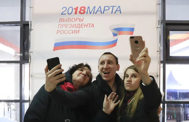 People take selfie pictures as they visit a polling station in Moscow, Russia on March 18, 2018. (Photo by Tatyana Makeyeva/Reuters)