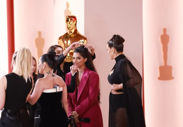 Canadian YouTuber Lilly Singh has her makeup and hair touched up as Ashley Graham looks on, on the champagne-colored red carpet during the Oscars arrivals at the 95th Academy Awards in Hollywood, Los Angeles, California, U.S., March 12, 2023. (Photo by Aude Guerrucci/Reuters)