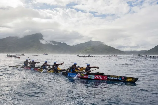 Participants exit the Huahine pass in the direction of Raiatea on the morning of November 4, 2015 for the first leg of the Hawaiki Nui Va'a 2015 outrigger canoe race. The Hawaiki Nui Va'a outrigger canoe race is an annual event with more than 100 team of intense racing between Huahine, Raiatea, Taha'a and Bora Bora, honoring an ancient sport with great cultural values. (Photo by Gregory Boissy/AFP Photo)