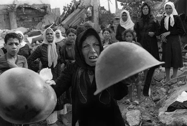 A Palestinian woman brandishes helmets during a memorial service in Beirut, September 27, 1982, for victims of Lebanon's Sabra refugee camp massacre.  She claimed the helmets were worn by those who massacred hundreds of her countrymen. (Photo by Bill Foley/AP Photo)