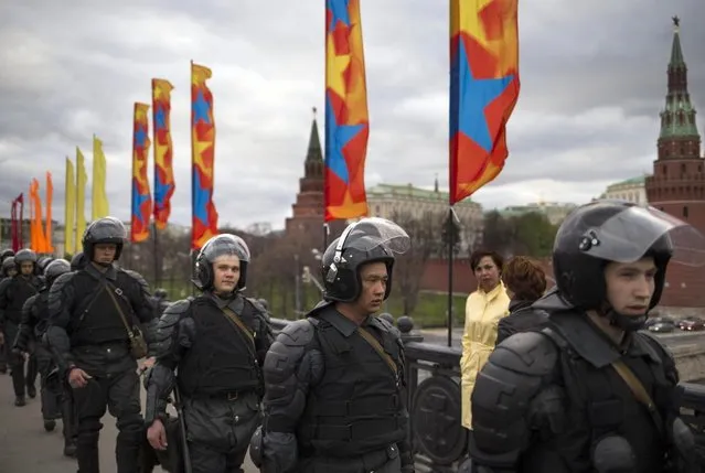 Russian riot police secure an area outside the Kremlin during a major protest rally in Bolotnaya Square in Moscow, Russia, Monday May 6, 2013. The rally marks the one-year anniversary of a protest on the eve of Putin's inauguration that ended in clashes between police and demonstrators. (AP Photo/Alexander Zemlianichenko)