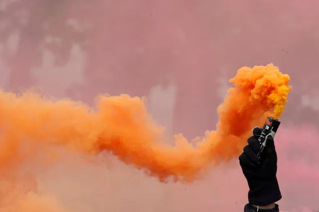 A protester holds a smoke safety flare during the May Day labour union march in Paris on May 1, 2018. (Photo by Christian Hartmann/Reuters)