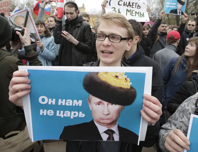 Demonstrators carry posters depicting Russian President Vladimir Putin during a massive protest rally in St.Petersburg, Russia, Saturday, May 5, 2018. Alexei Navalny, anti-corruption campaigner and Putin's most prominent critic, called for nationwide protests on Saturday, two days ahead of the inauguration of Vladimir Putin for a fourth term as Russian president. The sign on poster reading “He is not our czar”. (Photo by Dmitri Lovetsky/AP Photo)