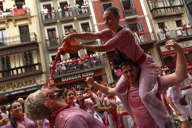 Revelers drink from leather wine sacks as they pack the main square during the official start of nine days of uninterrupted partying in Pamplona's famed running-of-the-bulls festival in Pamplona, Spain, Saturday, July 6, 2024. (Photo by Alvaro Barrientos/AP Photo)