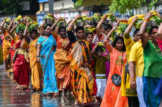 Hindu devotees participate in the annual festival of the Vishnu temple in Colombo on March 29, 2023. Hundreds of Hindu devotees attend the colourful celebrations during which the Tamil people parade through the streets surrounding the Vishnu temple. (Photo by Ishara S. Kodikara/AFP Photo)