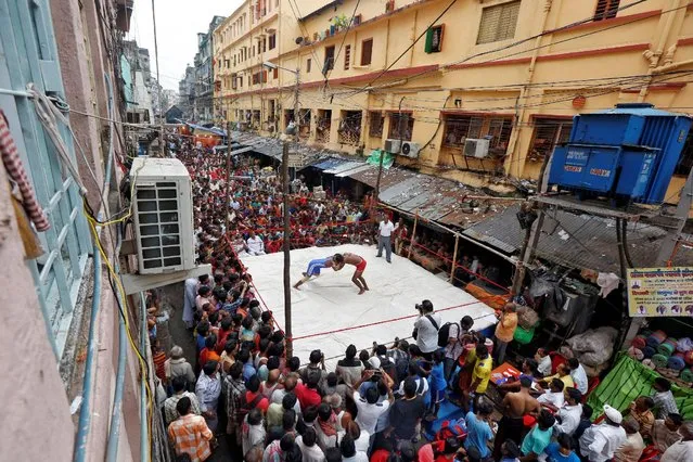 Wrestlers fight during an amateur wrestling match inside a makeshift ring installed on a road organised by local residents as part of the celebrations for the annual Hindu festival of Diwali in Kolkata, India, October 27, 2016. (Photo by Rupak De Chowdhuri/Reuters)