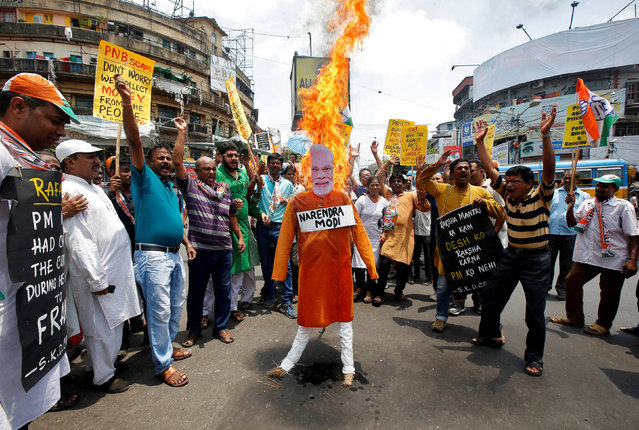 Supporters of India's main opposition Congress party shout slogans as they burn an effigy depicting India's Prime Minister Narendra Modi during a protest against the rise in fuel prices, in Kolkata, India, May 26, 2018. (Photo by Rupak De Chowdhuri/Reuters)